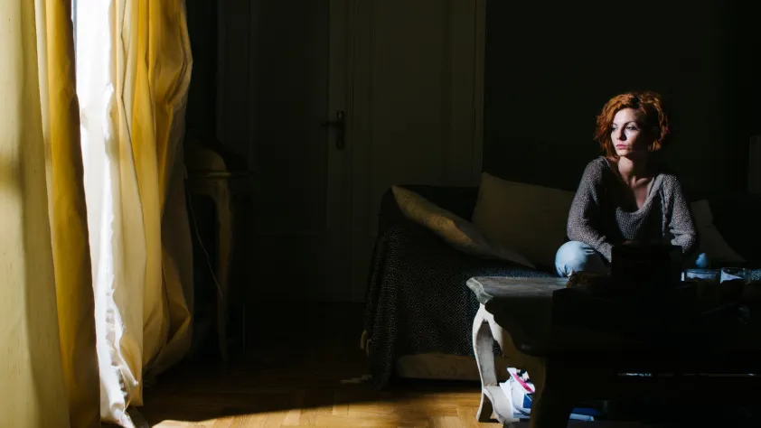 Person sitting in home looking out window