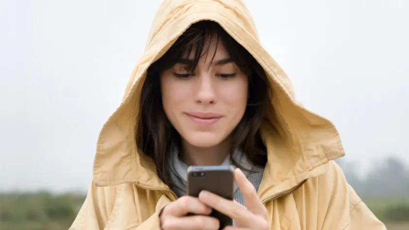 Pessoa usando uma jaqueta com capuz e contatando uma empresa pelo WhatsApp
