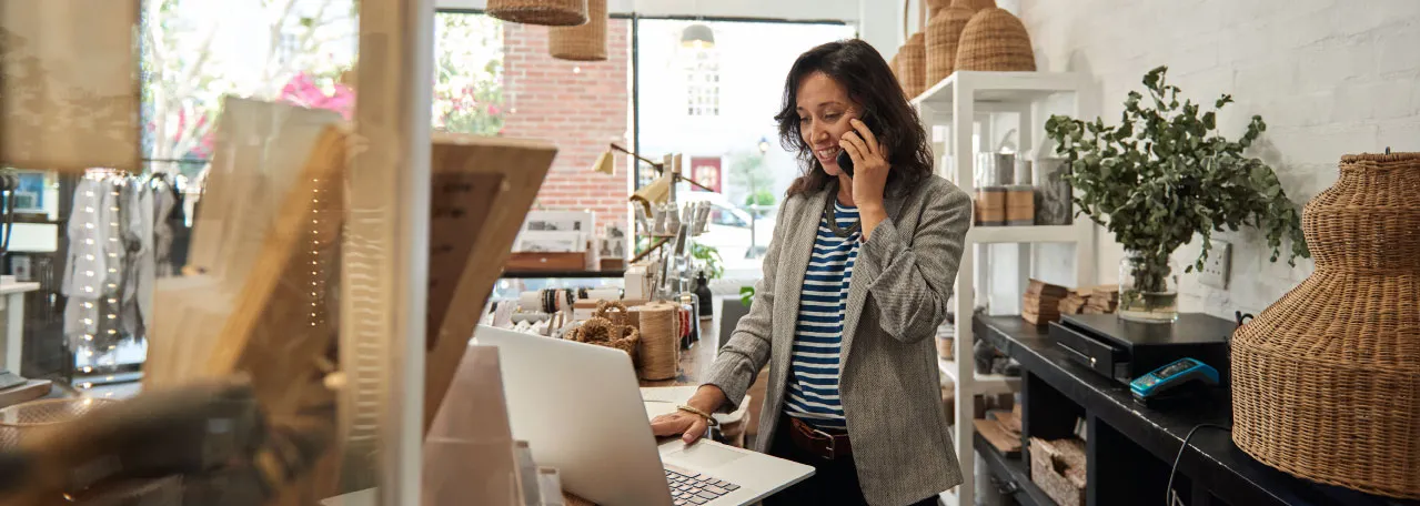 Dona de uma loja de luminárias falando ao telefone com um cliente