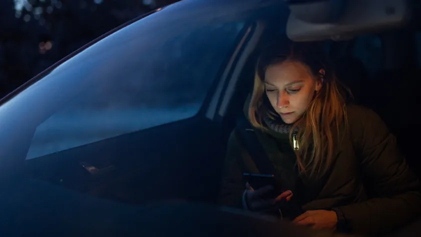 Persona en un auto realizando una compra a través de WhatsApp