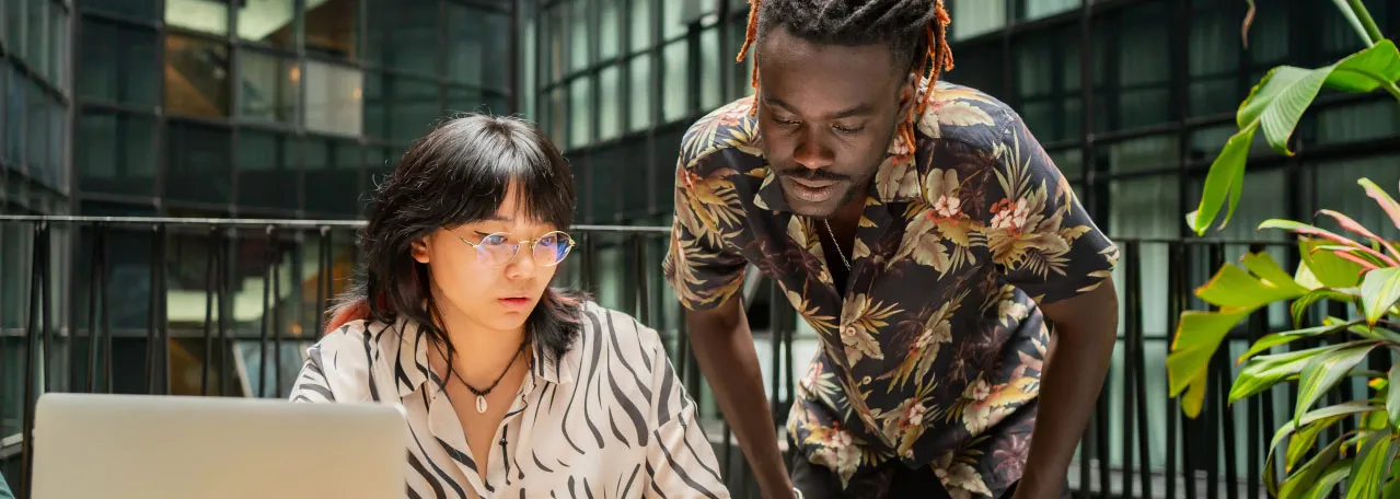 Dos colegas de marketing trabajando juntos en un escritorio