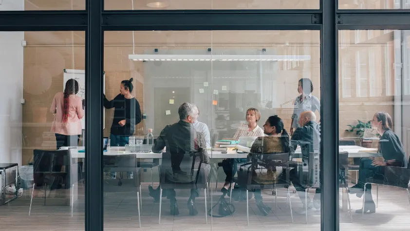 Meeting occurring in glass window conference room