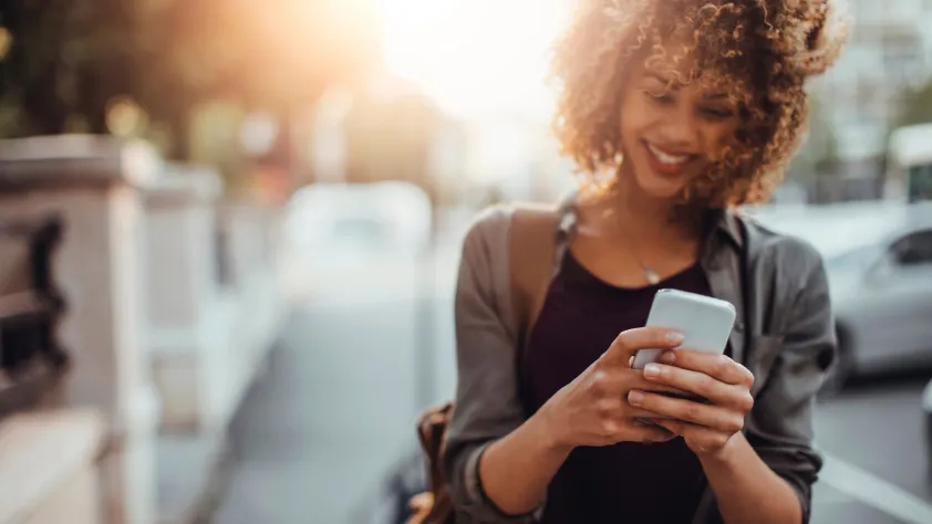 Person walking outside filling out feedback survey via WhatsApp