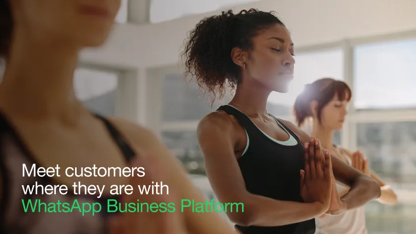 Tres mujeres haciendo yoga con un texto que dice: “encuentra a los clientes donde están con la Plataforma de WhatsApp Business”