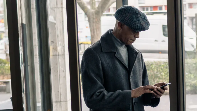 Person scrolling on phone at the bank