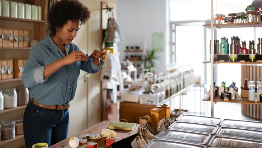 Store owner taking picture of inventory on phone to send to a customer via WhatsApp
