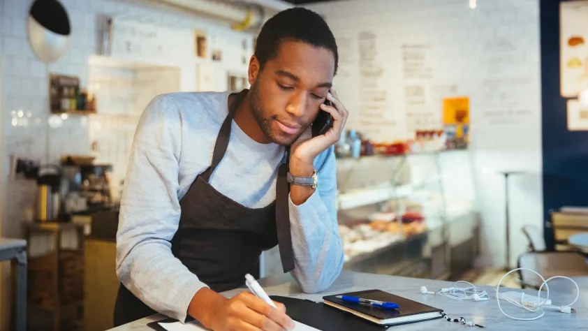 Person writing down a phone order in bakery