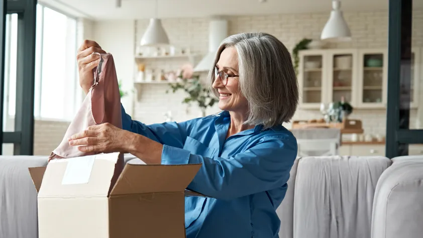 Person at home opening up a package on the couch