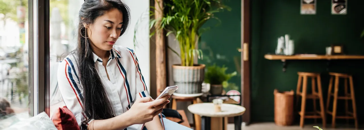 Person sitting in cafe reading on phone
