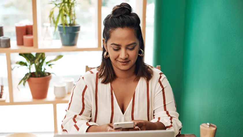 Person sitting at desk reading a message via WhatsApp