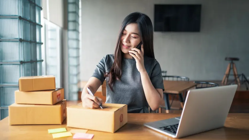 Person taking a phone order and preparing to send out the package
