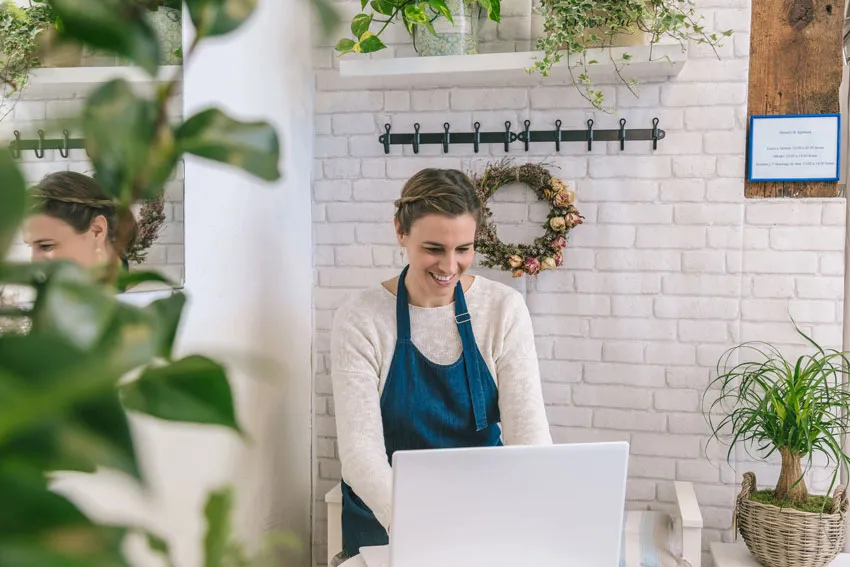 Person smiling and typing on their laptop