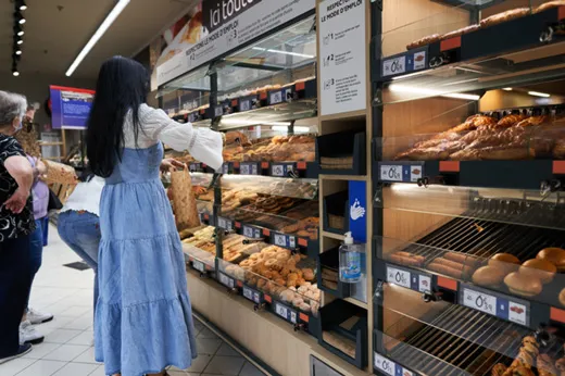 Woman picking up bread from a bred corner