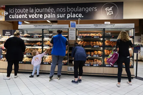 Des personnes au rayon boulangerie d’un supermarché