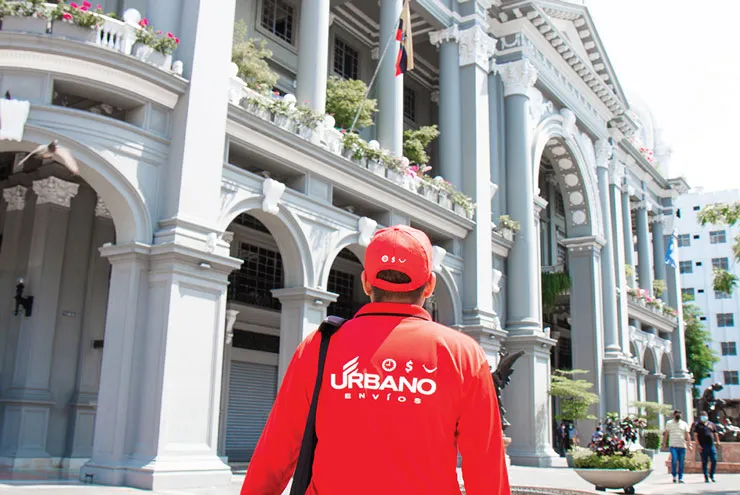 Un repartidor de Urbano Envíos frente a un edificio histórico
