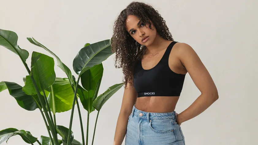Person standing next to plant modeling a Snocks sports bra