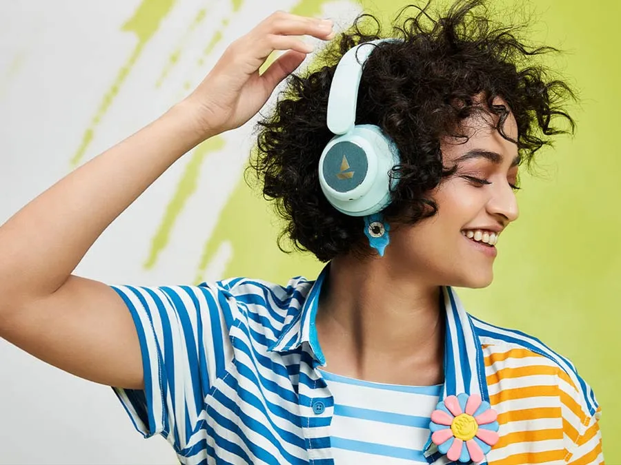 Uma mulher sorrindo ouvindo música em fones de ouvido