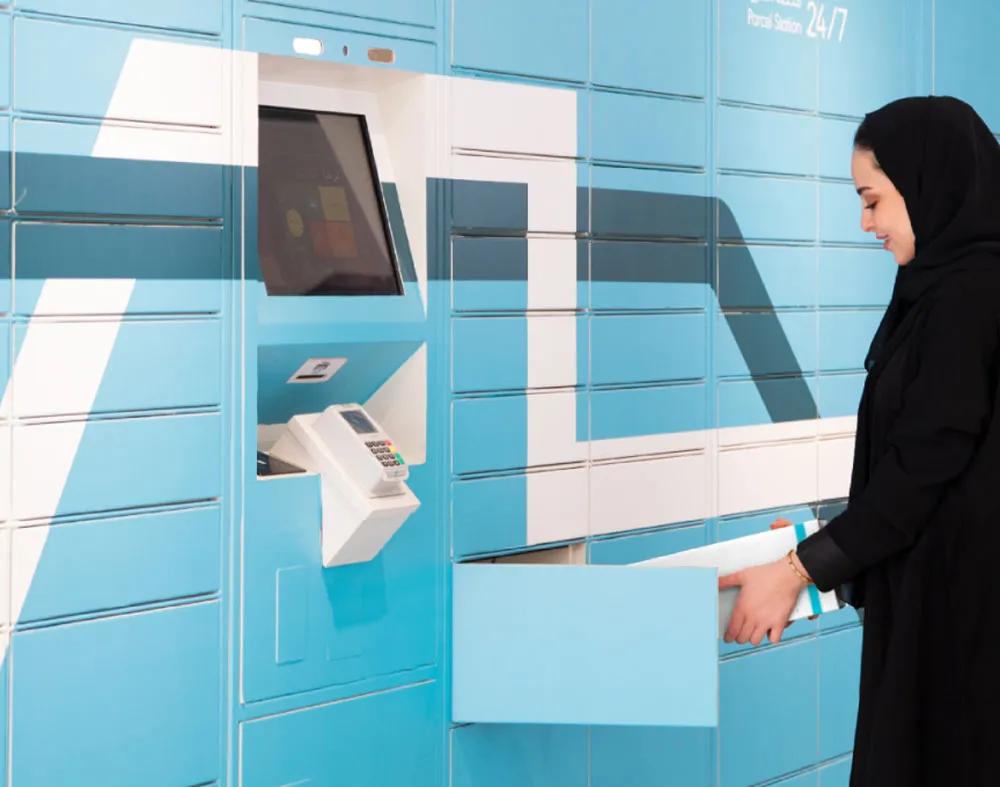A woman unlocking a SPL locker to retrieve her package.