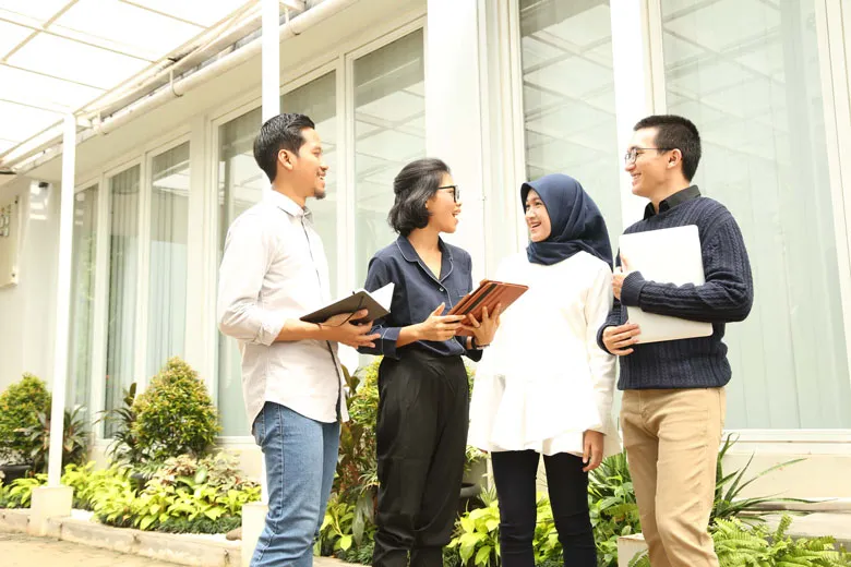 Sekelompok orang yang berdiri dan secara aktif terlibat dalam diskusi yang menarik.