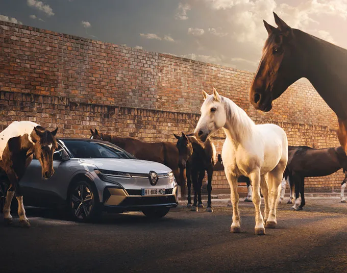 Une voiture Renault entourée de chevaux