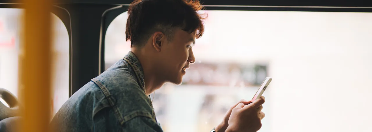 Person sitting on bus in front of window while reading a WhatsApp message about making a purchase