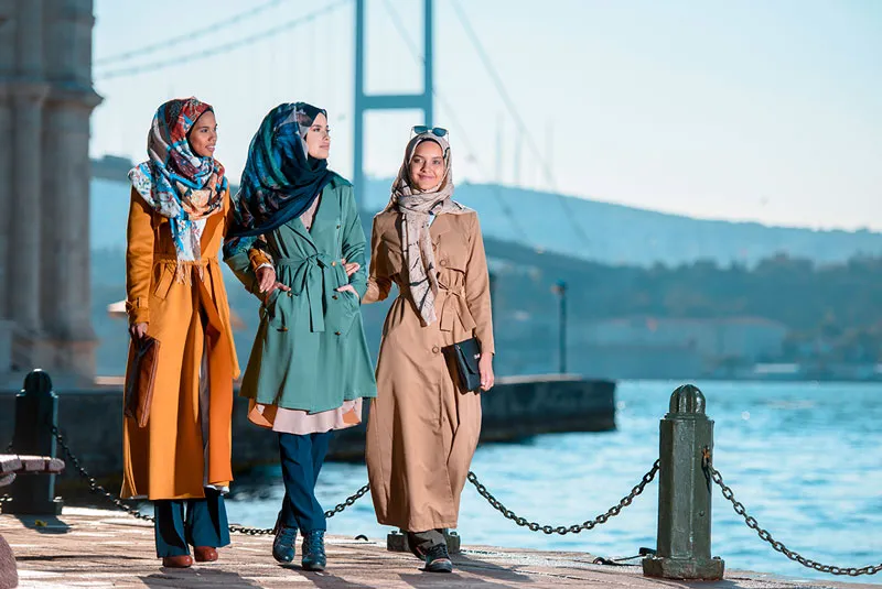 A group of women walking beside the bridge.