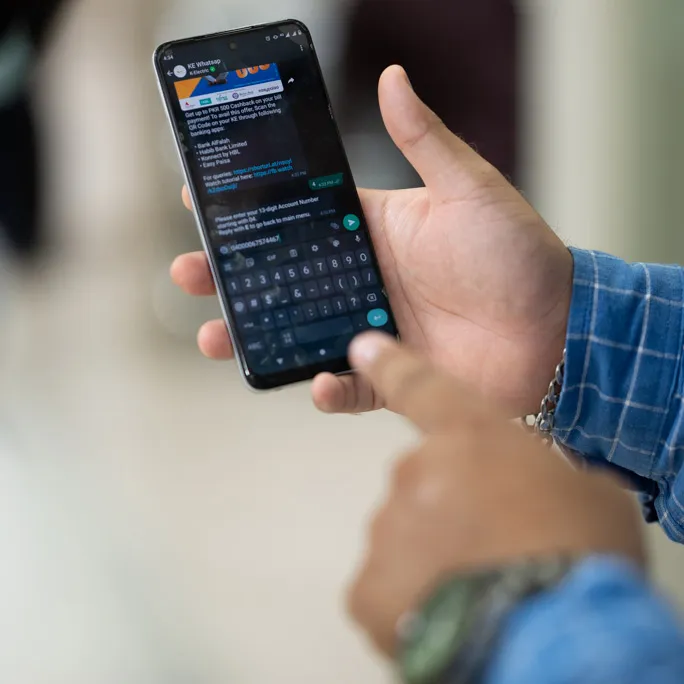 Un téléphone montrant un chat professionnel WhatsApp avec K-Electric