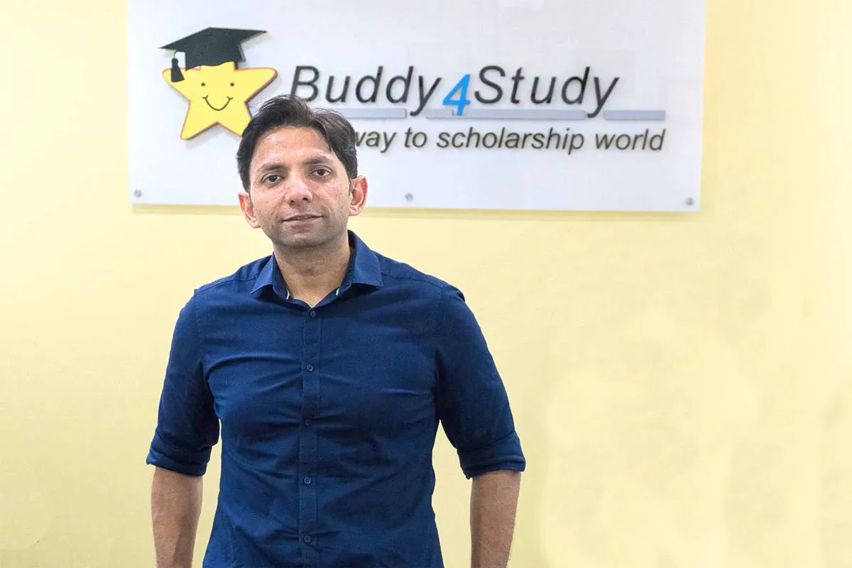 A man standing in front of the Buddy4Study sign