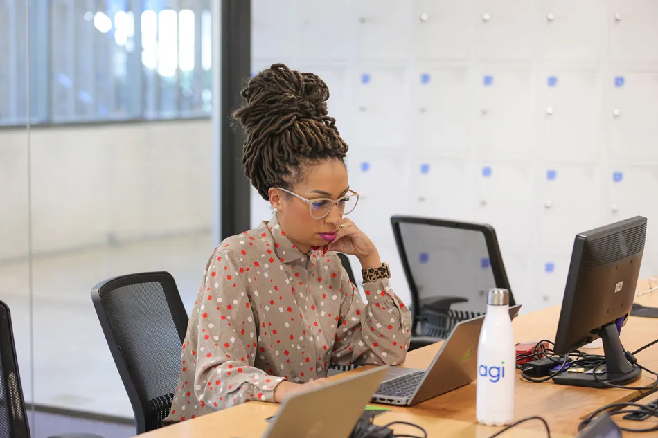 A woman seated at a desk within an office setting.