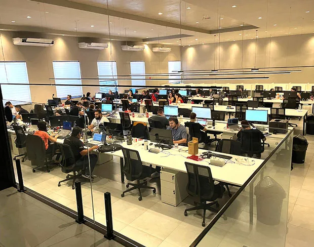 Scène de travail où l’on voit des membres du personnel assis à leur bureau.