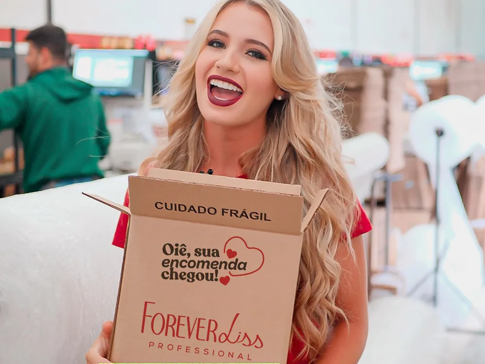 Uma mulher sorridente segurando um pacote da Forever Liss.