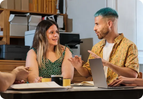 A man and woman sitting in an office, talking to each other