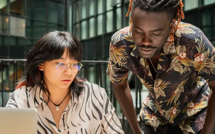 Two marketing colleagues working together at desk