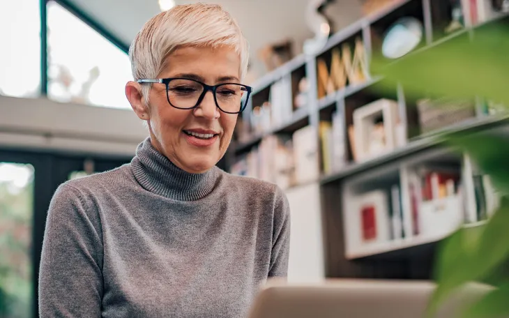Person with glasses at home working on laptop