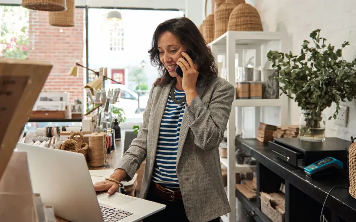 Lamp store owner talking on the phone with customer