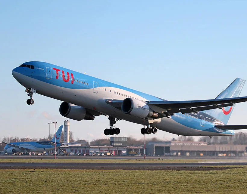 Un avion orné du logo TUI décollant d’un aéroport