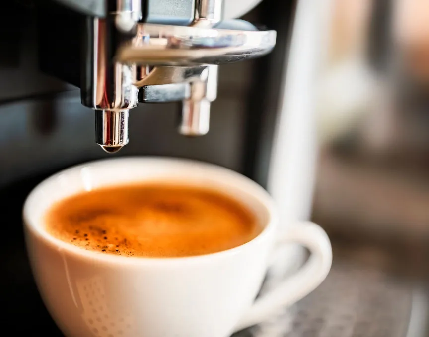 Una máquina de café preparando un expreso recién hecho en una taza