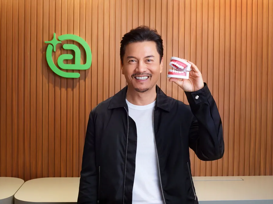 Un hombre sostiene una prótesis dental en la mano.