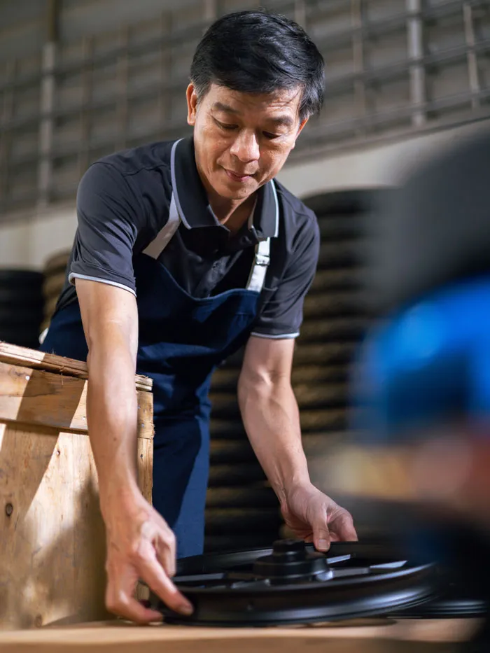 A man carefully bending over to pick up a plate