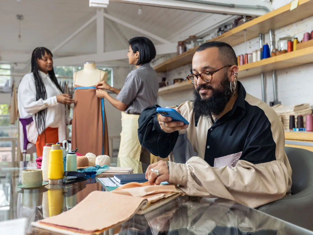 Un hombre sentado tomando una foto de un muestrario de colores