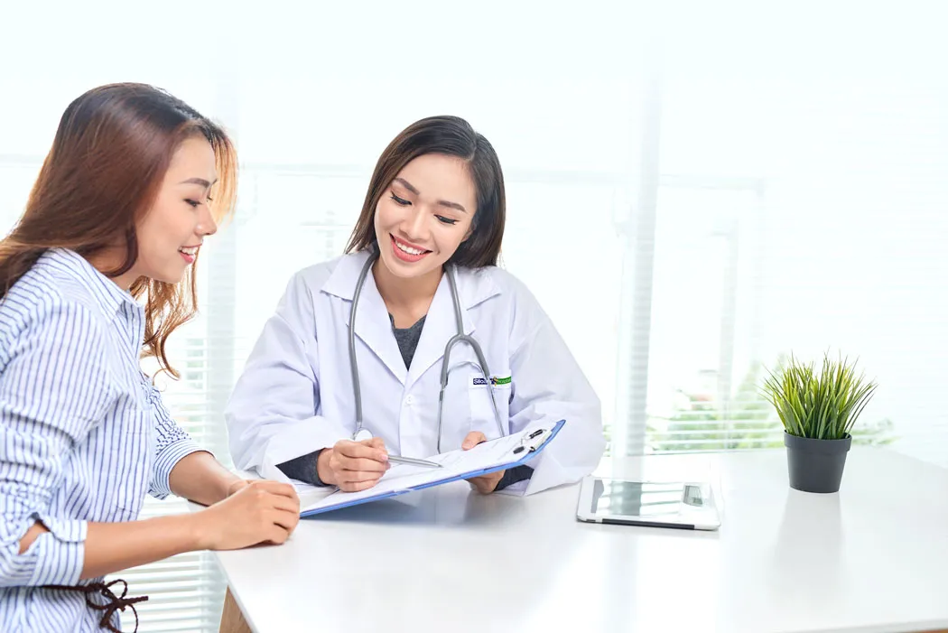 Uma médica sorridente apresentando documentos médicos a uma paciente