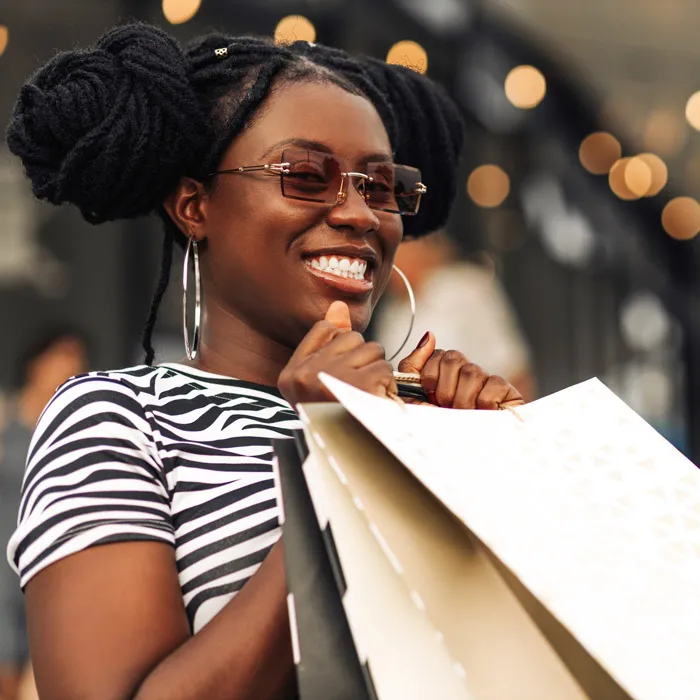 Une femme souriant avec des sacs de shopping