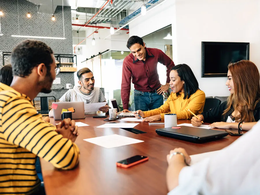 Wanita memberi presentasi kepada rekan kerjanya di kantor