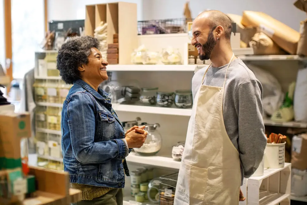 A man and a woman in a store together, smiling and laughing