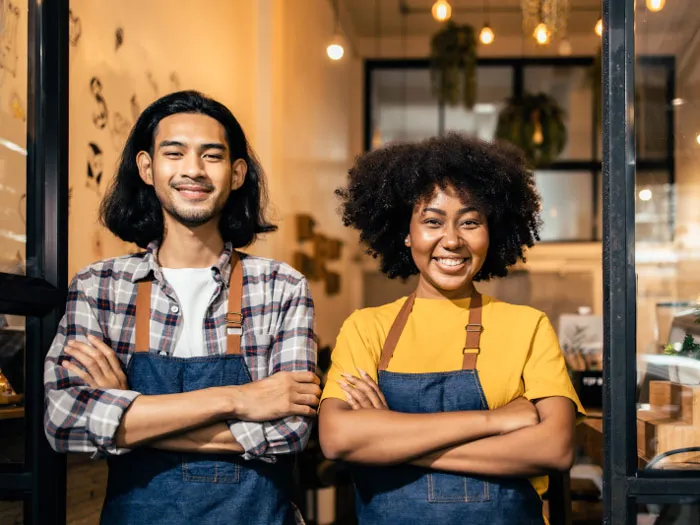 A man and a woman in a restaurant, smiling at the camera