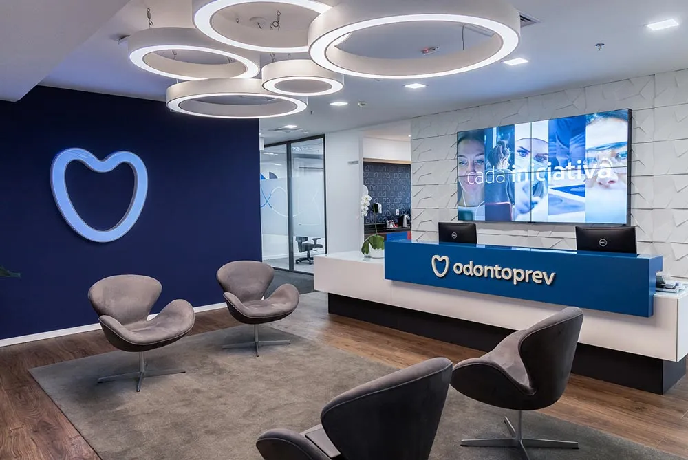 A dentist office lobby with a front desk and chairs