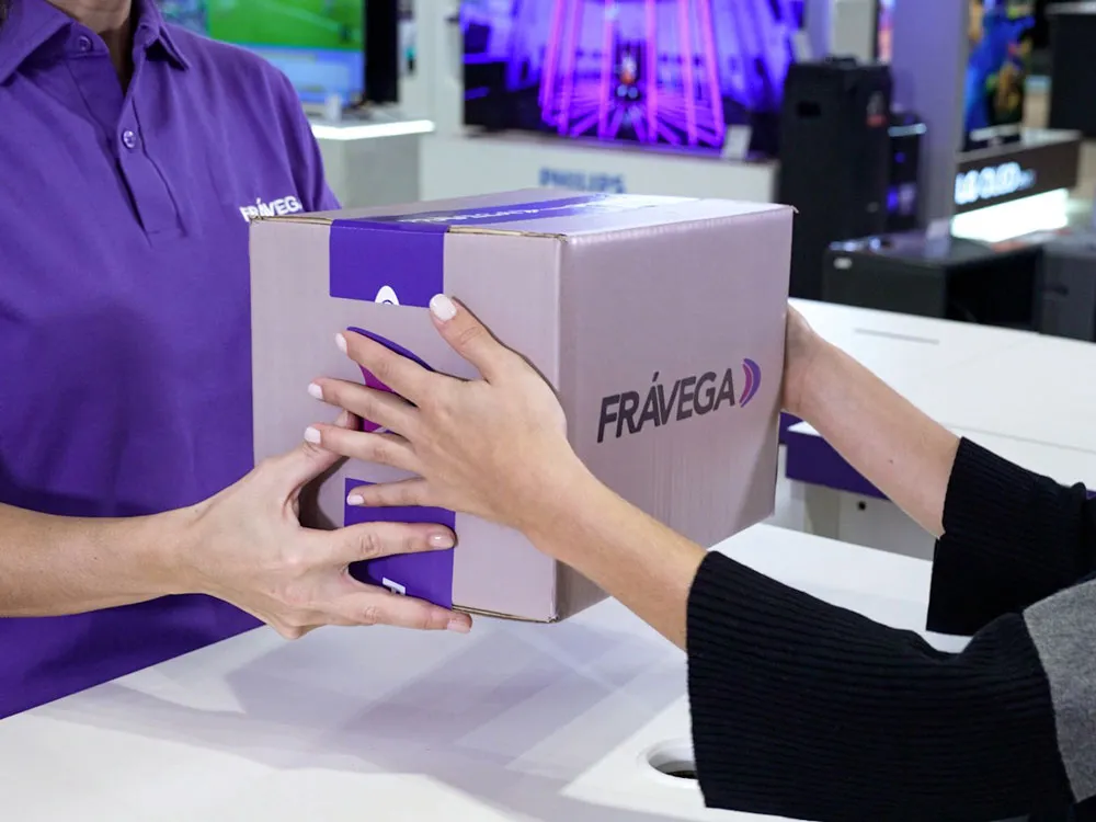 Funcionário da Frávega entregando uma caixa a um cliente