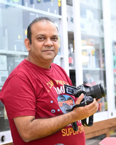 Un hombre en su tienda sosteniendo la cámara