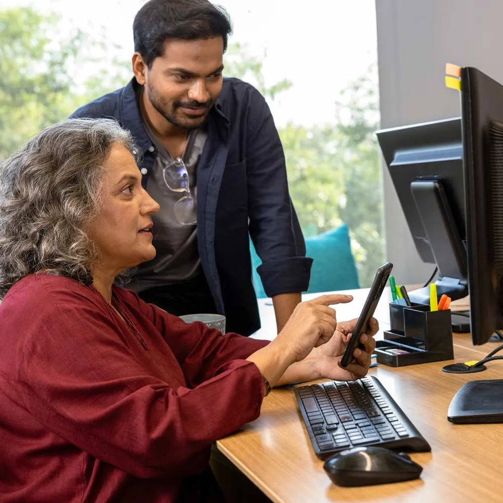 A man and woman having a discussion at an office desk discussing business messaging measurements
