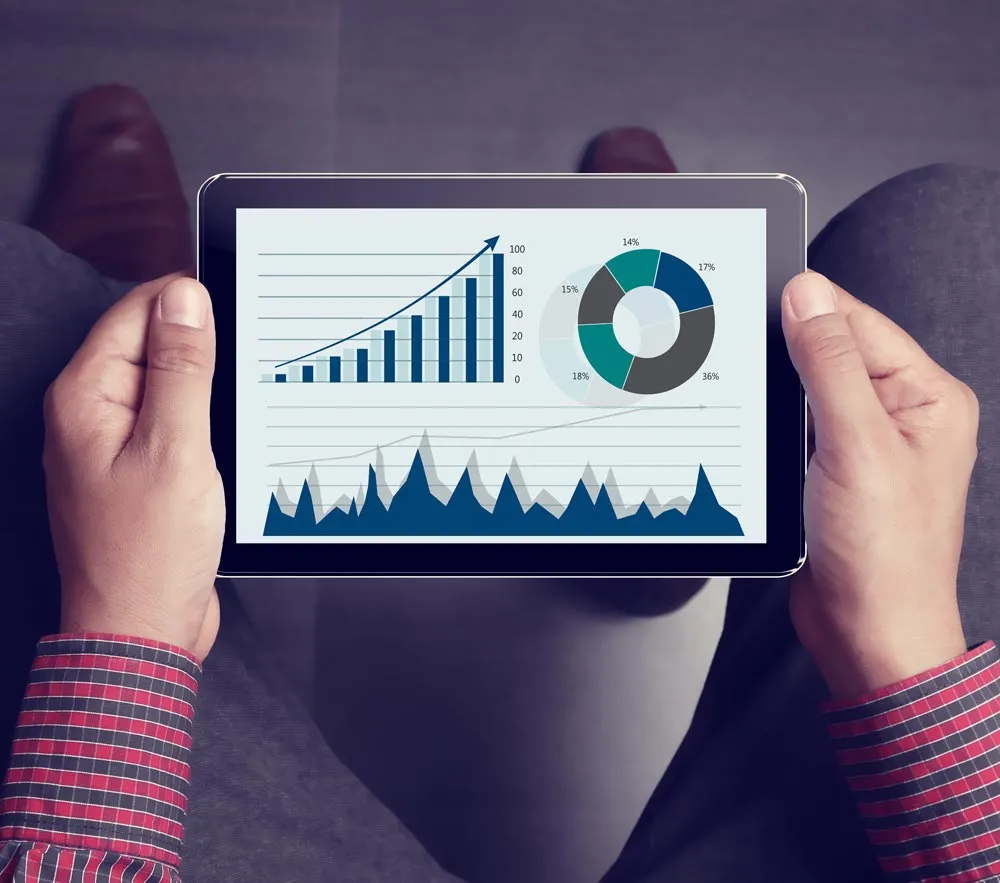 A man holding a tablet observation marketing metrics and graphics